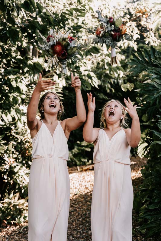 two girls throwing bouquets in the air