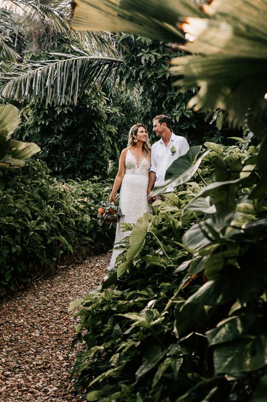 bride and groom walking in the rainforest