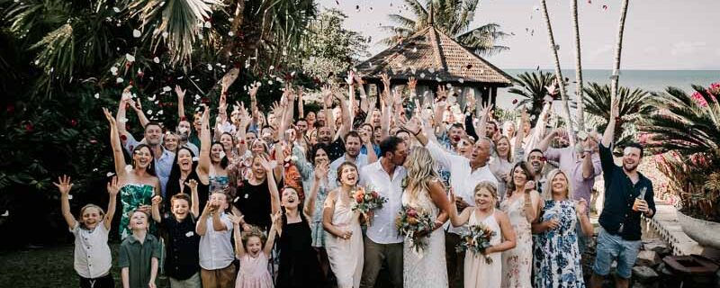 Wedding guests throwing petals in celebration group shot