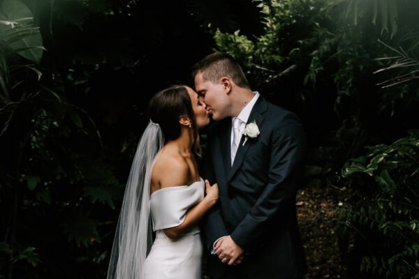 bride and groom kissing in villa botanica rainforest