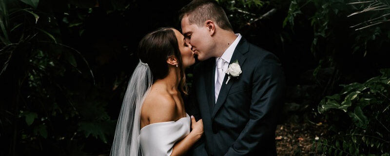 bride and groom kissing in villa botanica rainforest