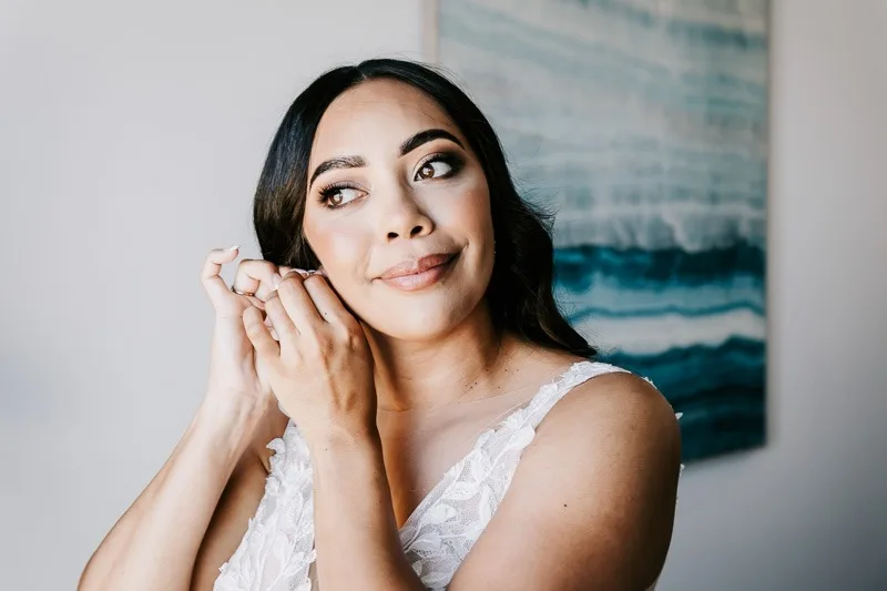 bride putting in earrings
