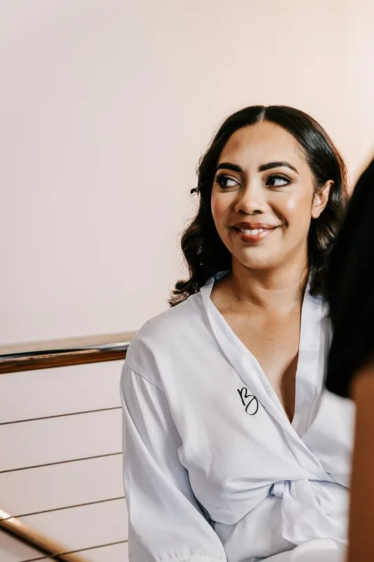 bride in robe gettin makeup done