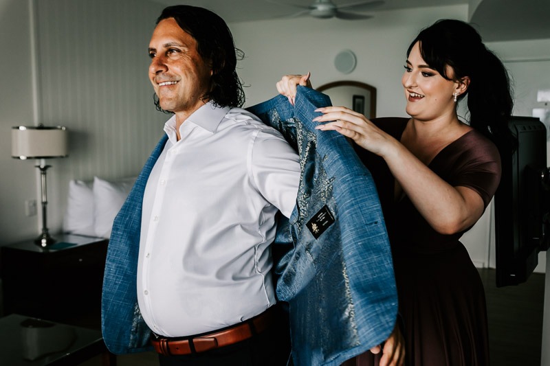 groom puttin on jacket with daughter