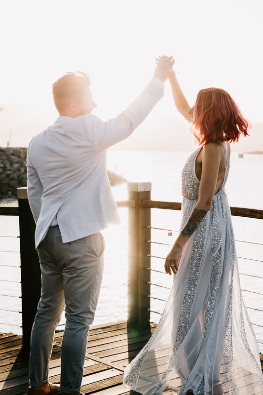 bride and groom on boardwalk sunset dancing