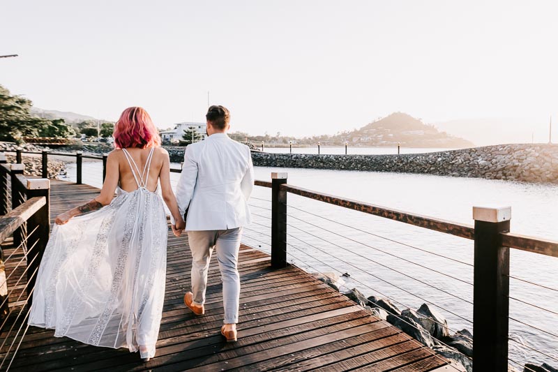 bride and groom on boardwalk sunset