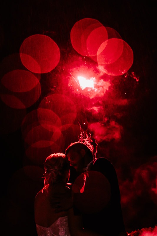 bride and groom fireworks in the rain