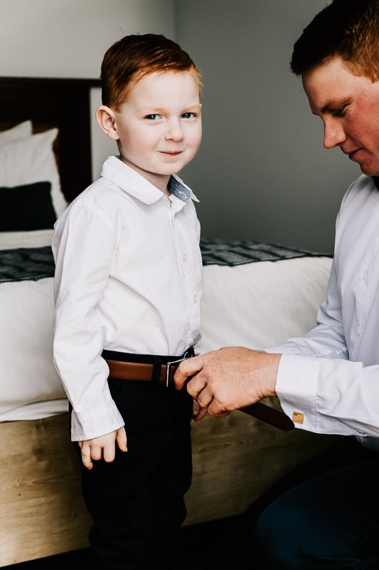 groom helping son to dress
