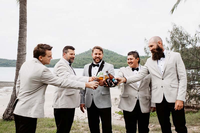 groom cheers with groomsmen