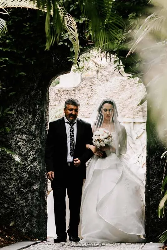 father and bride walk down the aisle