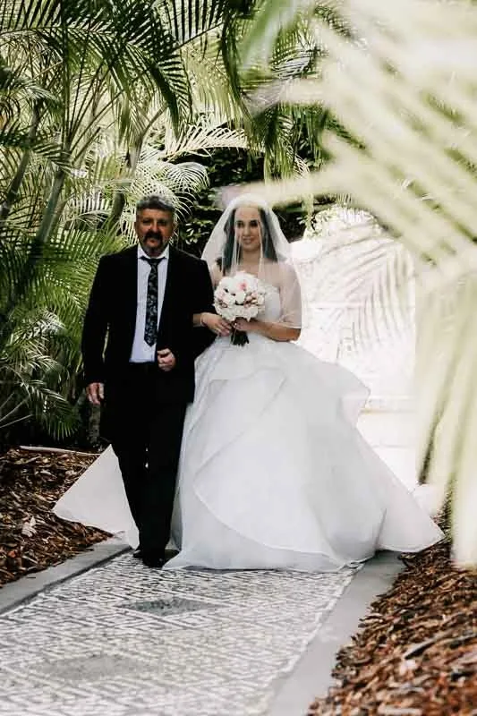 father and bride walk down the aisle
