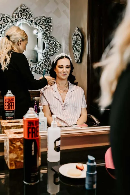 reflection of bride getting her hair done