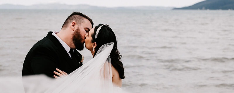 bride and groom kiss with veil