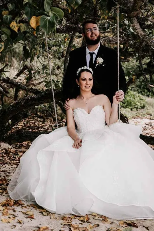 groom pushing bride on swing