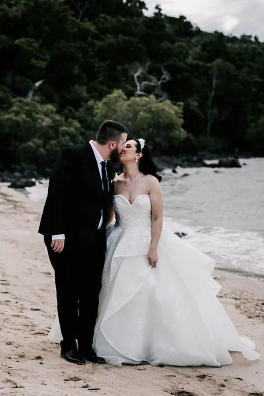 bride and groom kiss on beach