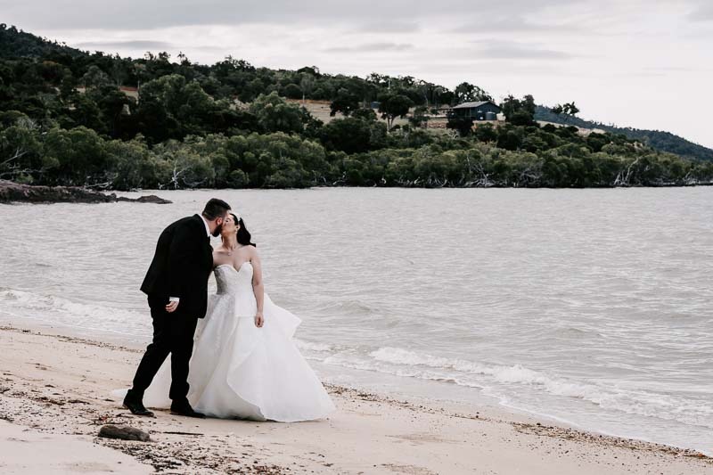 bride and groom kiss on beach