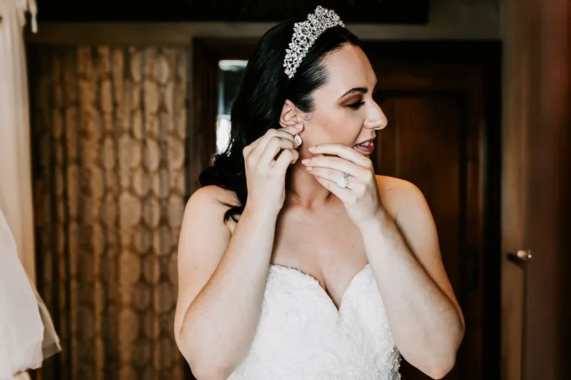 bride putting on earrings