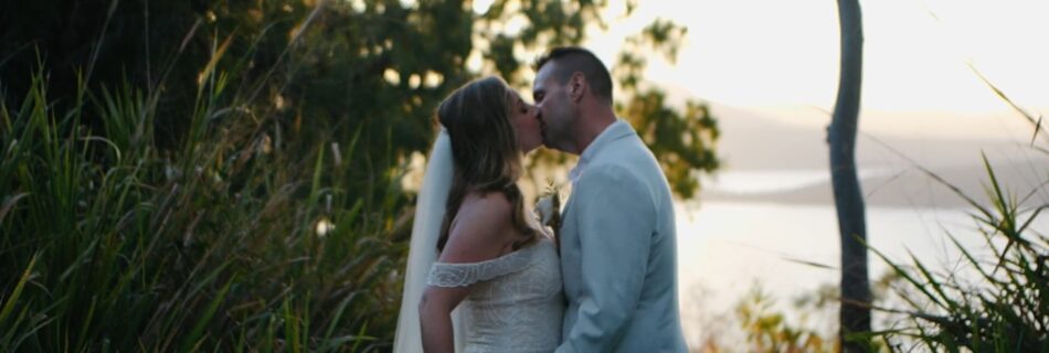 Bride and Groom kissing in grass