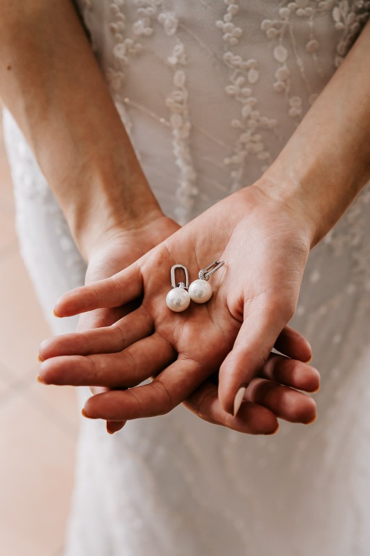bride holding earrings