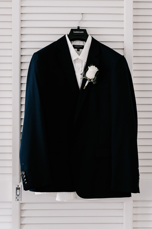black suit jacket hanging on wardrobe