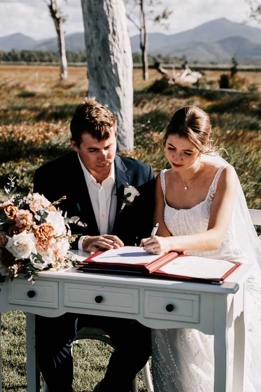 bride and groom sign marrige certificate