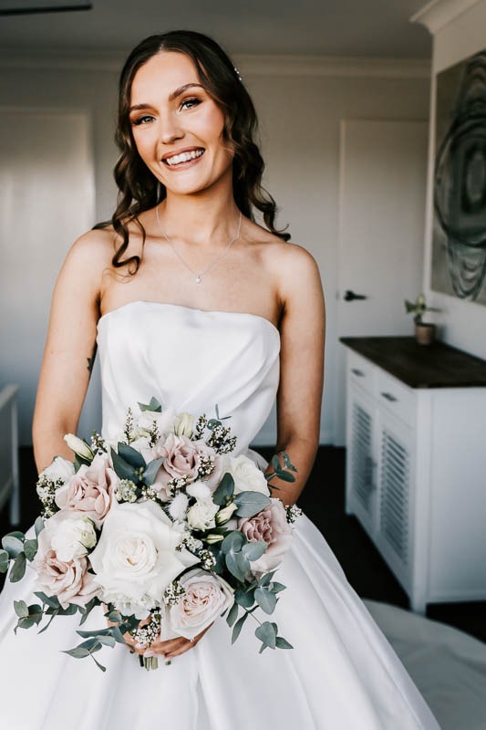 Bride smiling holding bouquet