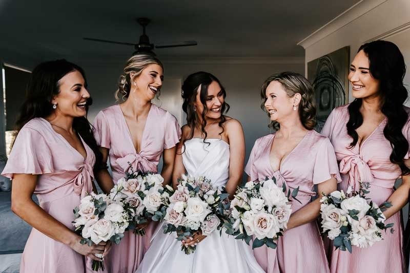 Bride smiling with bridesmaids