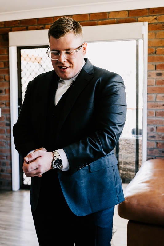 Groom fixing cuffs on jacket