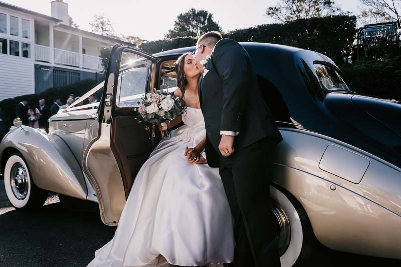 Bride & Groom kiss in vehicle