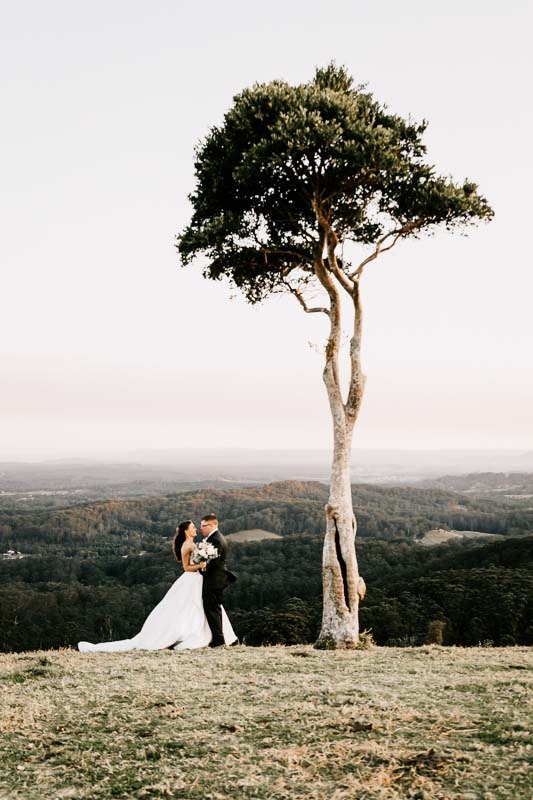 Bride & Groom embrace in front of tree