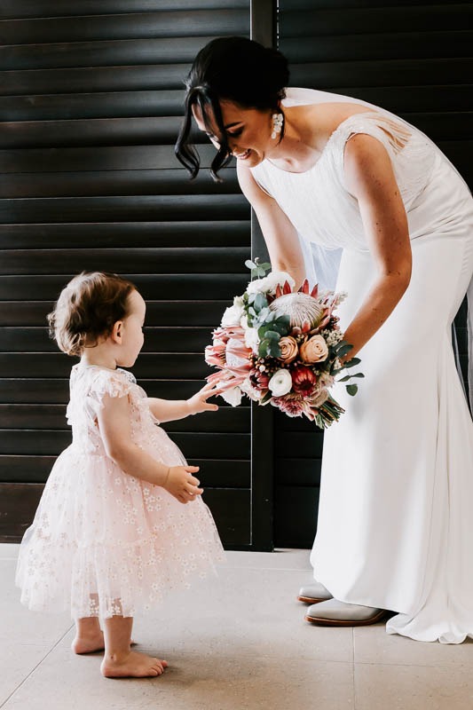 Bride and child looking at bouquet