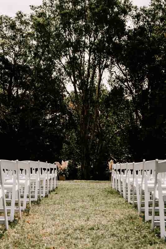 Ceremony chairs in bush setting tall shot
