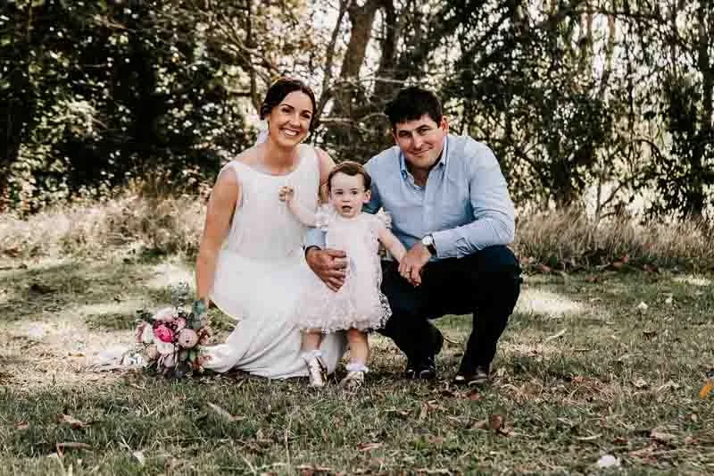 Bride & Groom pose with child