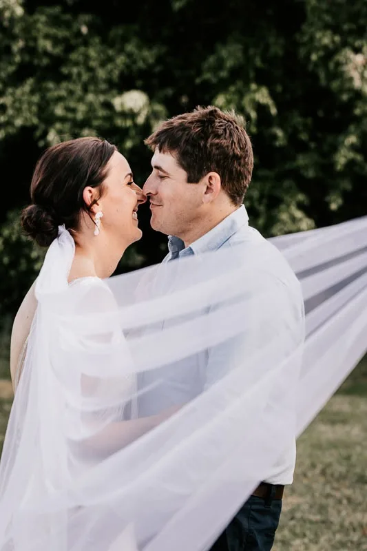 Bride & Groom kiss with veil in foreground
