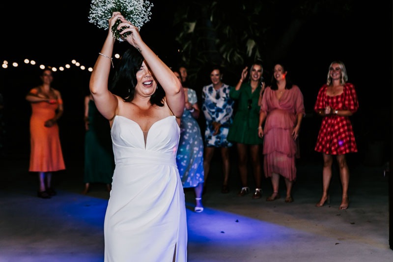 Bride throwing bouquet to guests