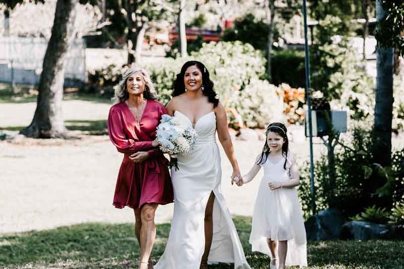 Mother walking Bride down isle holding daughters hand