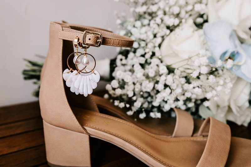 Brides shoes with bouquet and earrings