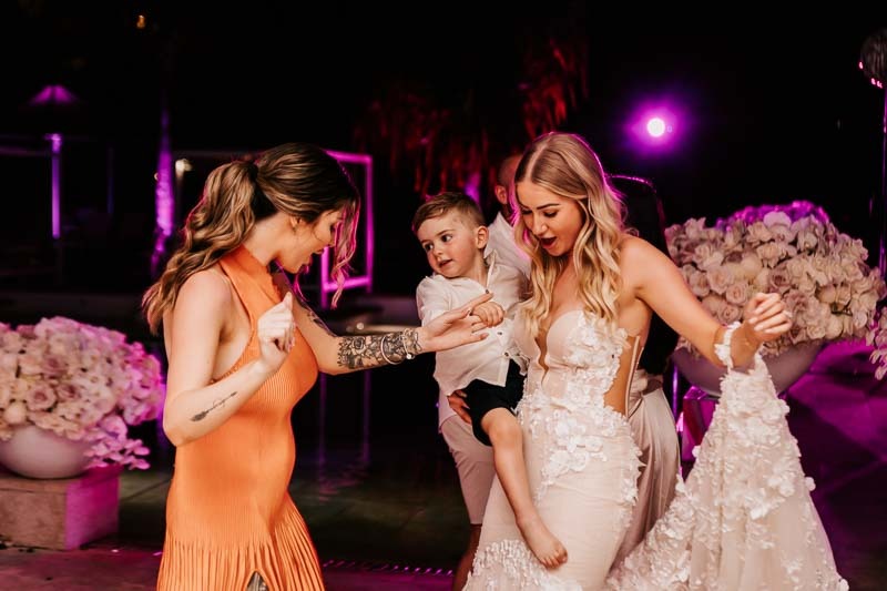 Bride dancing with young boy and woman