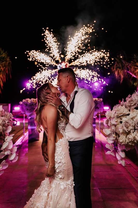 Bride & Groom kiss in front of fireworks