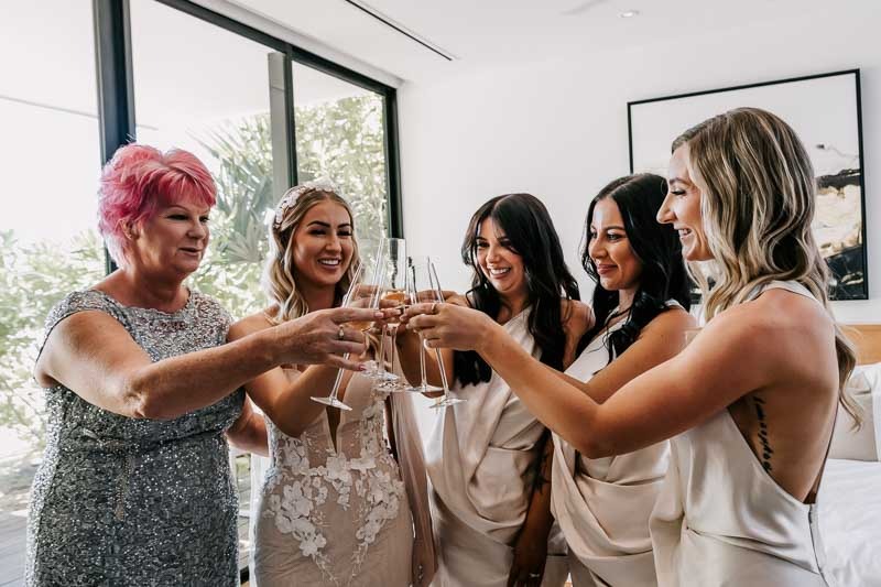 Bride and mother cheers with bridesmaids