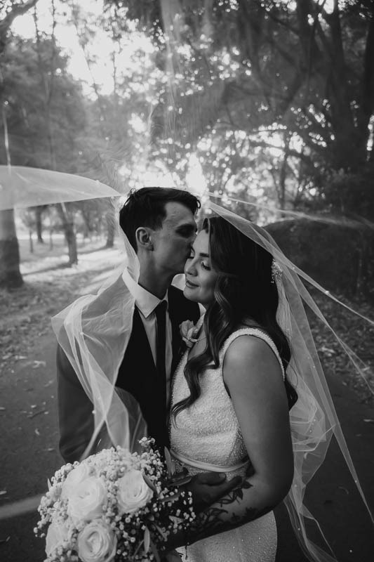 Groom kisses bride under veil