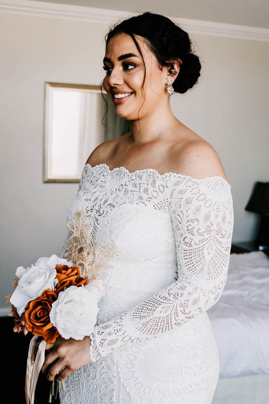 Bride smiling holding bouquet