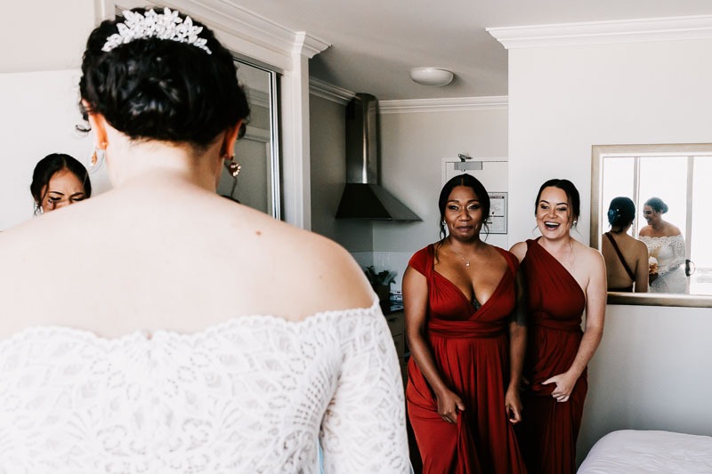 Bridesmaids react to bride in dress