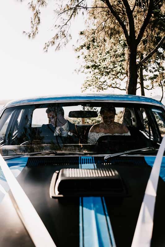 Bride & Groom in backseat of blue car