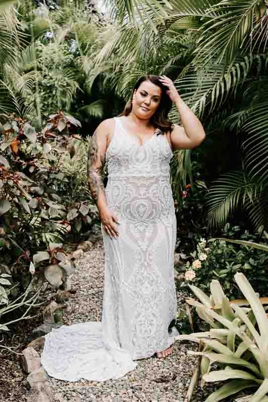 Bride poses with greenery behind