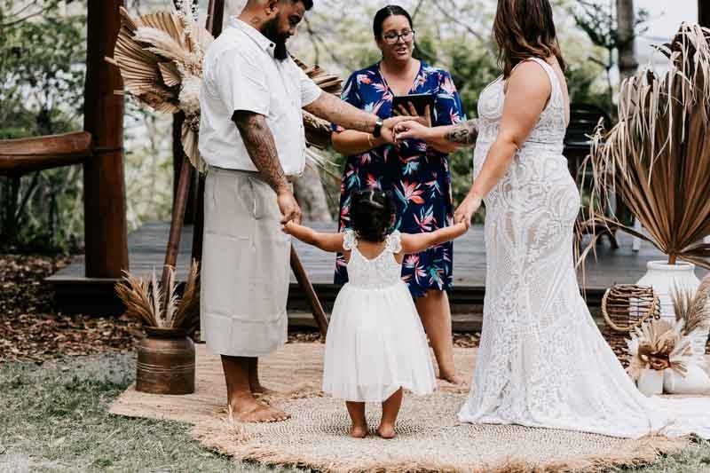 Bride & Groom hold hands with daughter