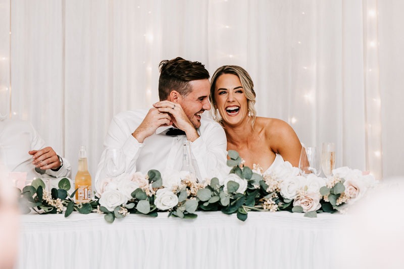 Bride & Groom laugh with each other at reception
