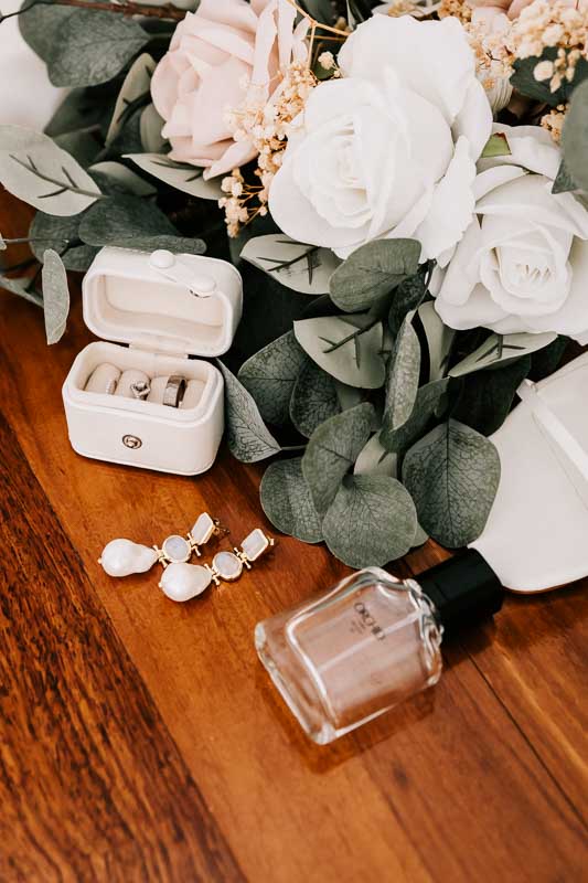 Brides jewellery with bouquet, rings and perfume