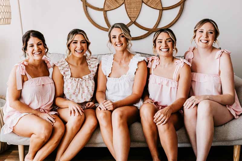 Bride & Bridesmaids sit on couch