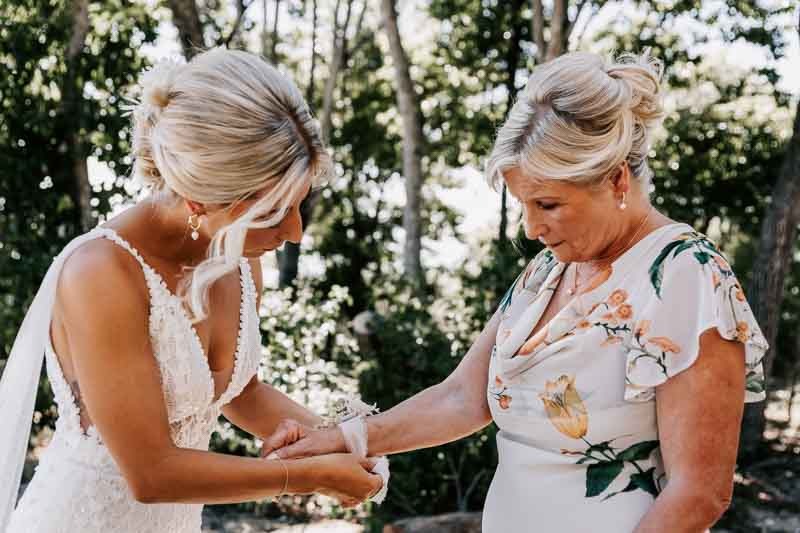 Bride putting corsage on Mother